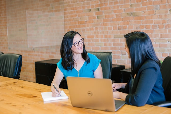 Sales rep sitting down with client and getting feedback from them.