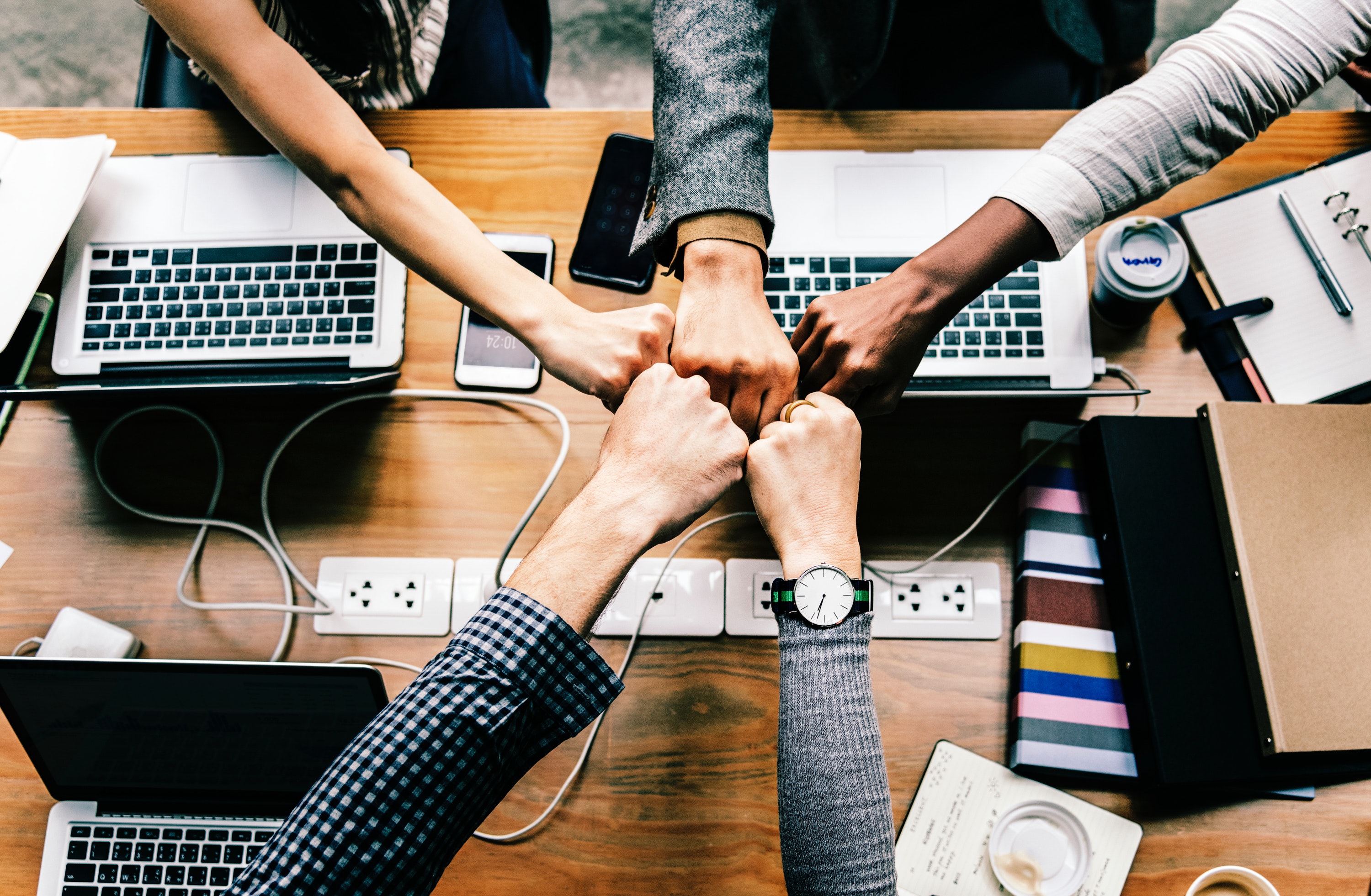 Sales and marketing teams fist bumping to show unity