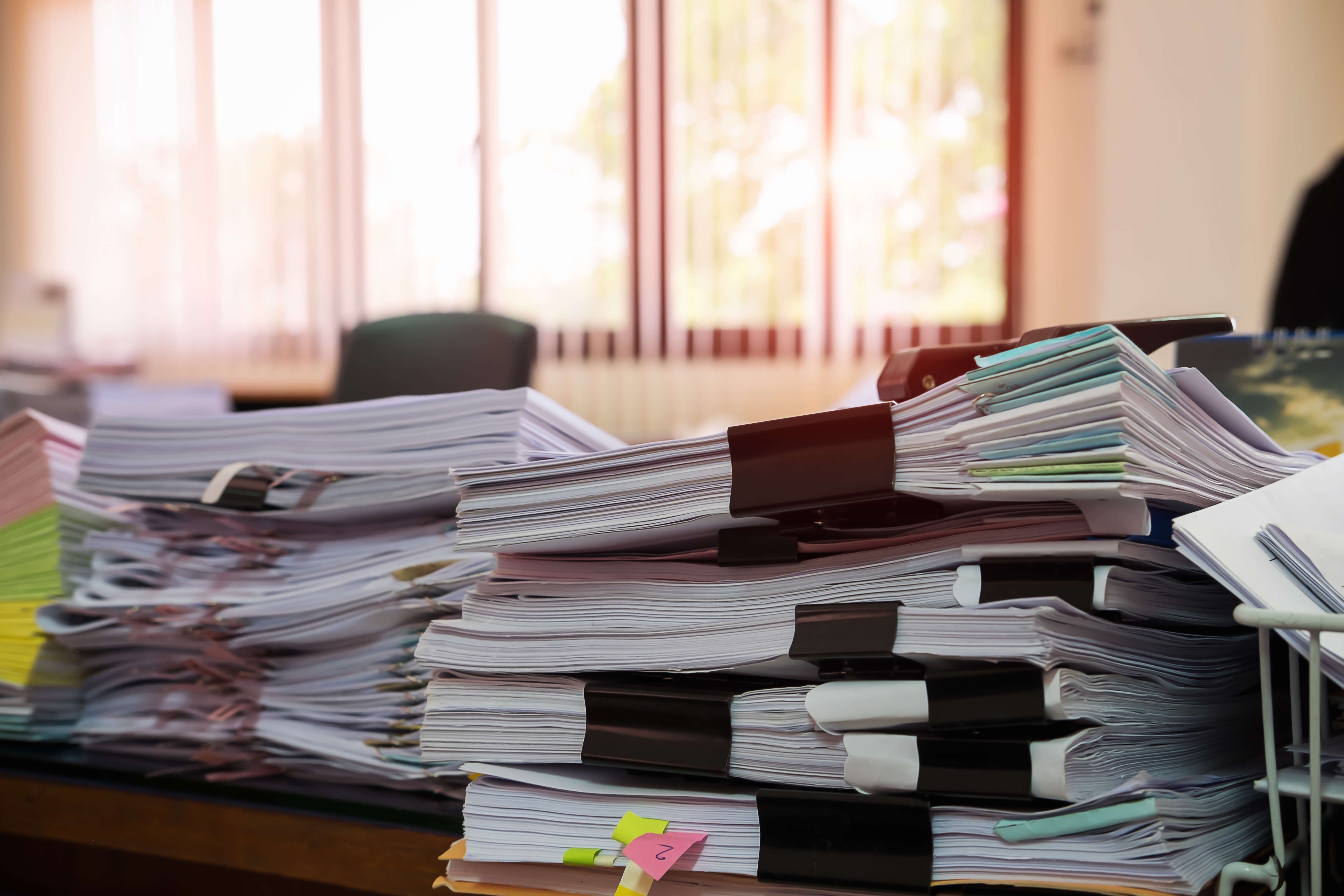 Stacks of incomplete paperwork due to misaligned communication channels
